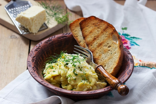 Frittata di piatto tradizionale moldavo o rumeno con formaggio, servita con pane su una superficie di legno.