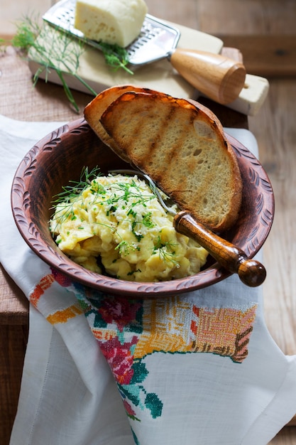 Frittata di piatto tradizionale moldavo o rumeno con formaggio, servita con pane su una superficie di legno.