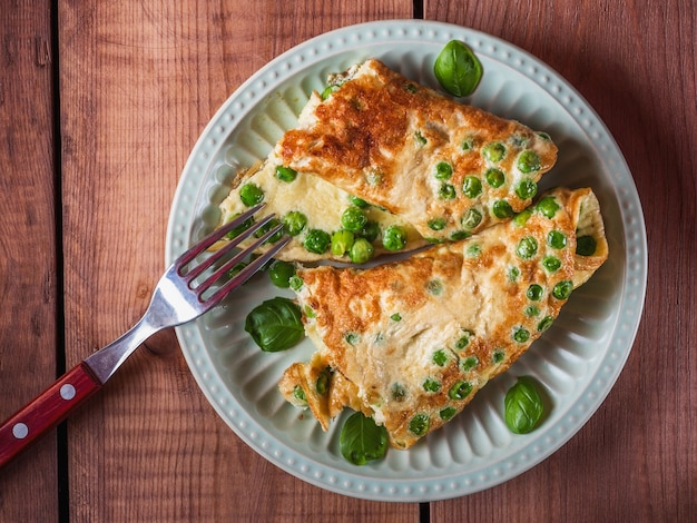 Frittata di piselli con foglie di basilico, deliziosa colazione proteica su un piatto piatto