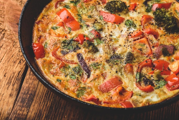 Frittata di verdure con broccoli, peperone rosso e cipolla rossa in padella di ghisa