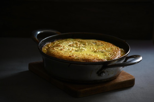 Frittata rustica con patate in una padella di metallo sul tavolo della cucina