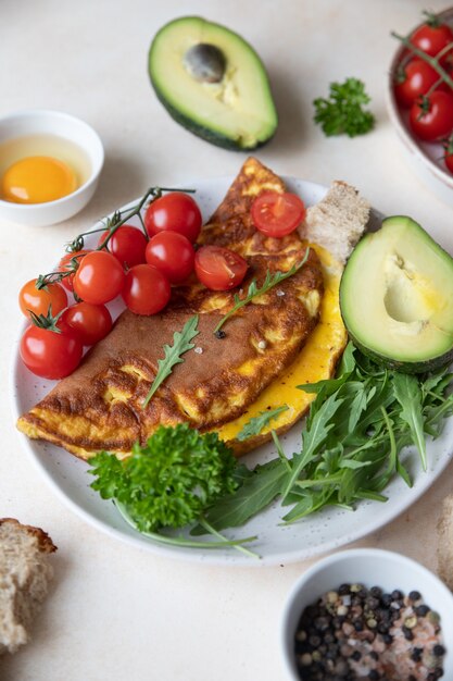 Frittata servita con pomodorini avocado e rucola su piatto in ceramica