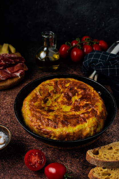 Frittata spagnola tradizionale della tortiglia sulla tavola rustica scura