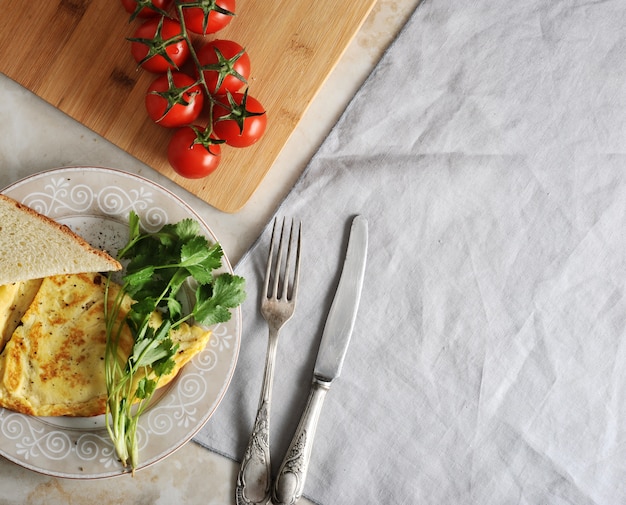 Frittata su un piatto, prezzemolo, pomodori, toast