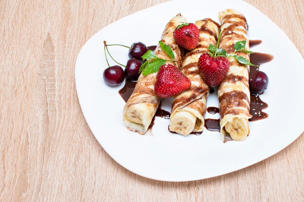 Frittelle con banana e fragole su un piatto