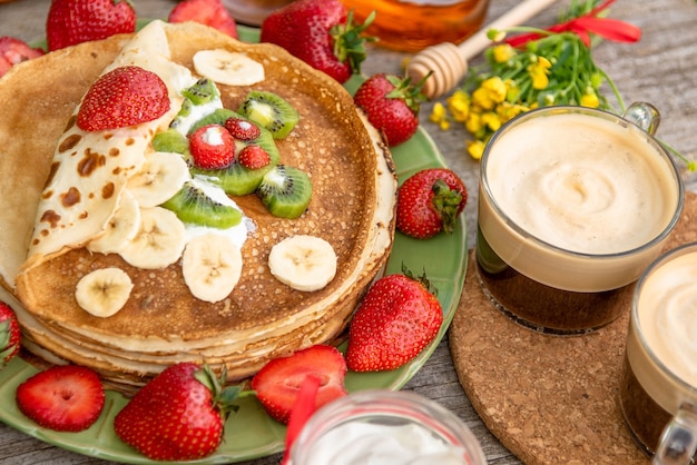 Frittelle con frutta e caffè per colazione.