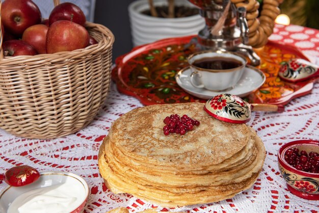Frittelle con frutti di bosco e panna acida sul tavolo shrovetide maslenitsa concetto di festival