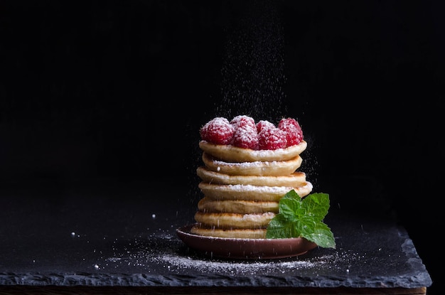 Frittelle con lamponi su sfondo nero