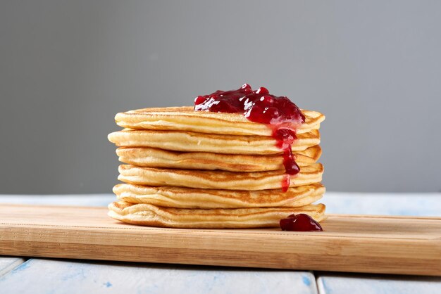 Frittelle con marmellata di bacche rosse sul tavolo di legno