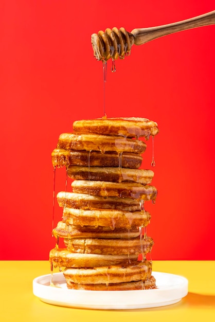 Frittelle con miele su sfondo colorato luminoso Graphic Food Studio Photo