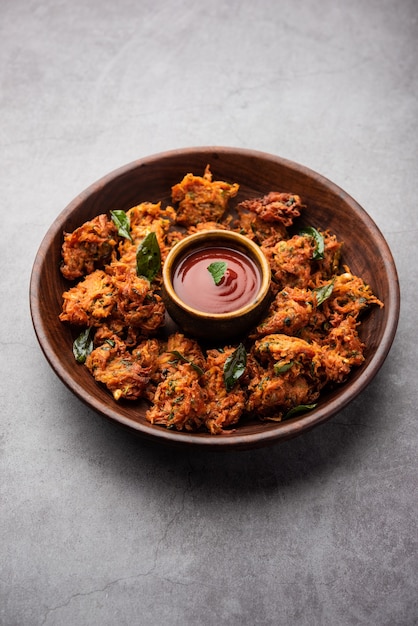 Frittelle di carote o Gajar ke pakore o pakode o bajji o bhaji, snack indiano servito in un piatto con ketchup