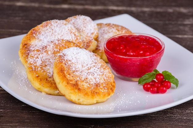 Frittelle di formaggio con marmellata di frutti di bosco nel piatto bianco Primo piano