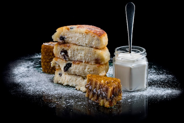 Frittelle di formaggio con uvetta isolata sul nero