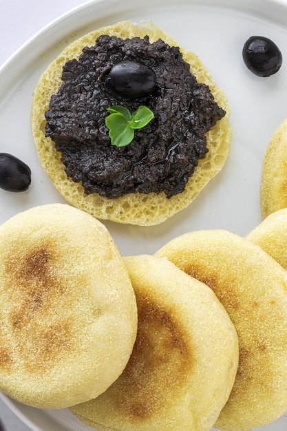 Frittelle di pane di semola di harcha fatte in casa con purè di olive Cibo arabo concetto di cibo halal