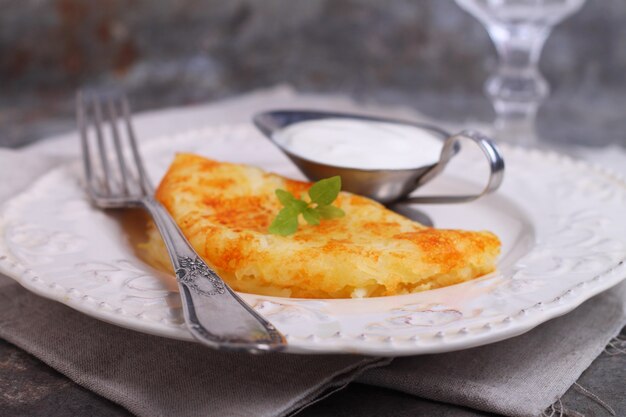 Frittelle di patate con panna acida in un piatto bianco