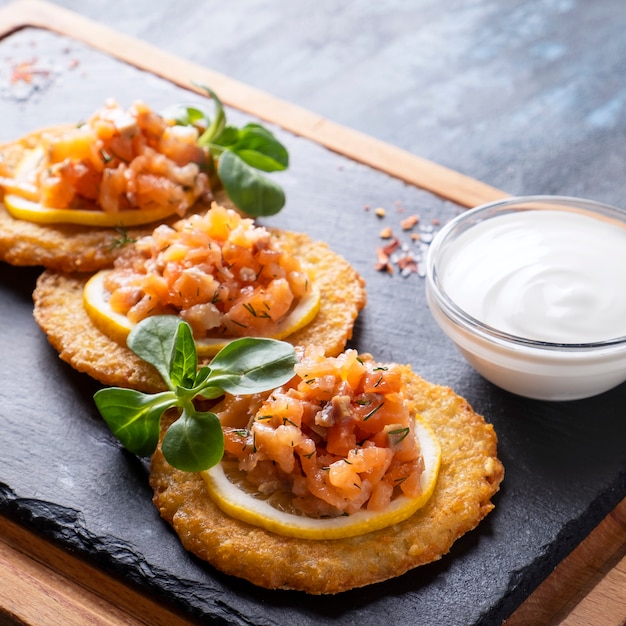 Frittelle di patate con salmone e panna acida.