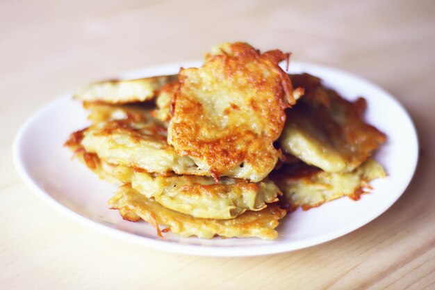 Frittelle di patate fatte in casa in un piatto bianco su un tavolo di legno