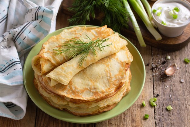 Frittelle di patate non dolci servite con salsa di crema di aglio su tavola in legno rustico