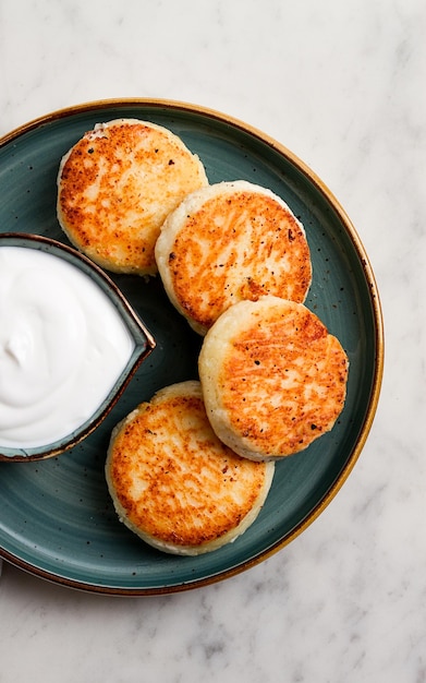 Frittelle di ricotta fritte con panna acida Cheesecakes su un tavolo in marmo vista senza persone