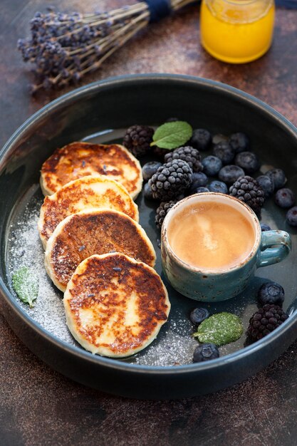 Frittelle di ricotta syrniki con frutti di bosco e miele