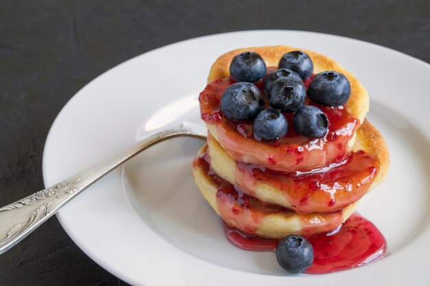 Frittelle di ricotta, syrniki con frutti di bosco freschi.