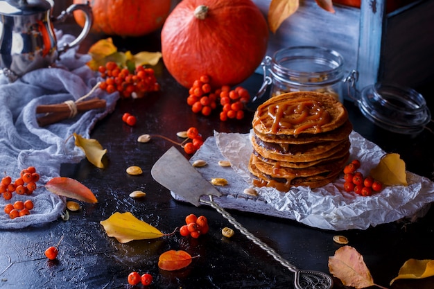 Frittelle di zucca con topping al caramello, con zucche, foglie.