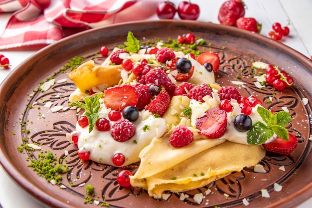 Frittelle fatte in casa con panna acida e frutti di bosco