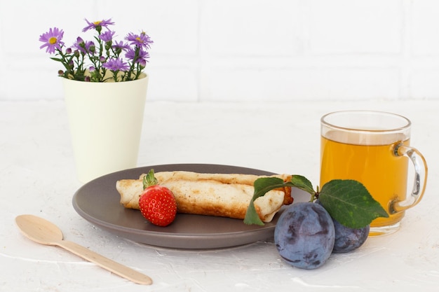 Frittelle fatte in casa ripiene di ricotta una fragola con un cucchiaio di legno una tazza di tè