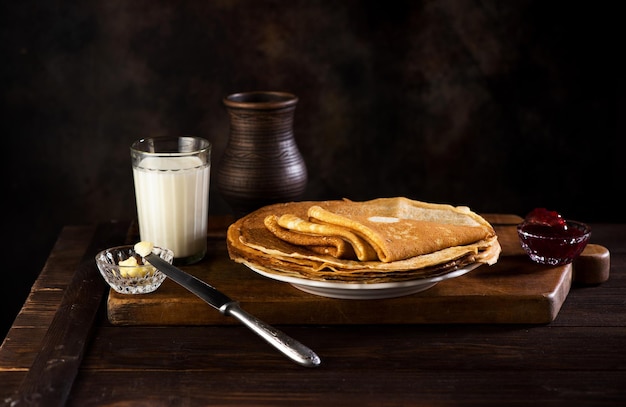 Frittelle frittelle sottili o crepes con marmellata su un piatto bianco