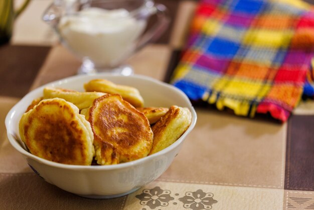 Frittelle russe fatte in casa sulla ciotola di ceramica sul tavolo da pranzo