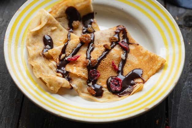 Frittelle sottili versare crepes al cioccolato sciroppo piatto bianco piatto torta