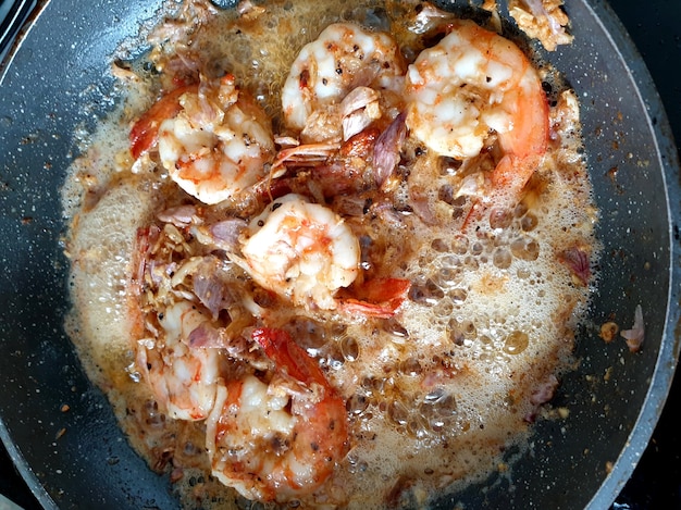 Frittura di gamberi con aglio e pepe in padella calda