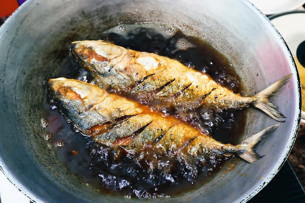 Frittura di pesce salata in padella con olio da cucina, concetto di cibo in stile tailandese