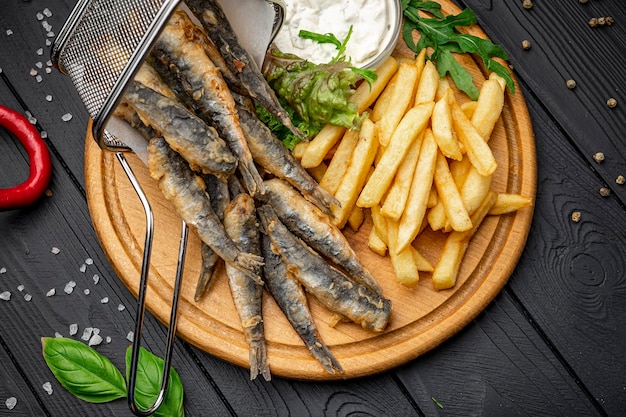 Fritture di pesce e patatine fritte in un ristorante sul mare Acciughe fritte