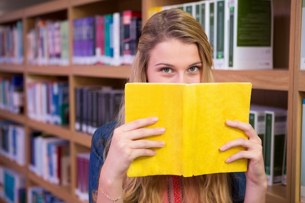 Fronte della copertura dello studente con il libro in biblioteca