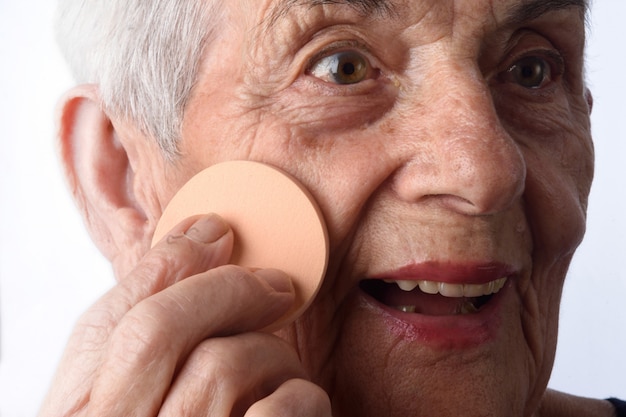 Fronte di trucco della donna maggiore su priorità bassa bianca