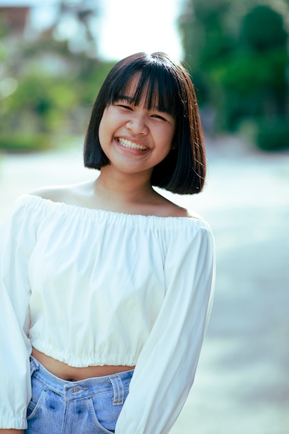 Fronte sorridente a trentadue denti dell'adolescente asiatico allegro con il momento di felicità