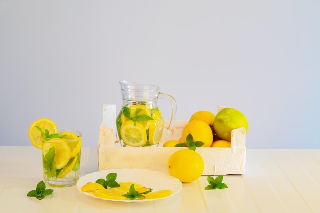 Fruitscut pezzi di limone foglie di menta bevanda al limone in una brocca fiori bevanda salutare con menta e limone