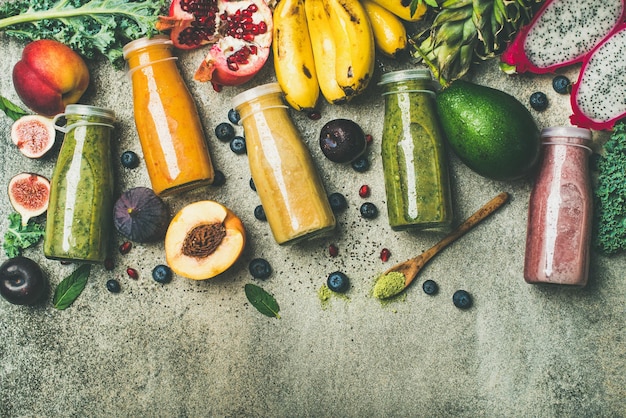 Frullati colorati in bottiglia con spazio per la copia di frutta fresca