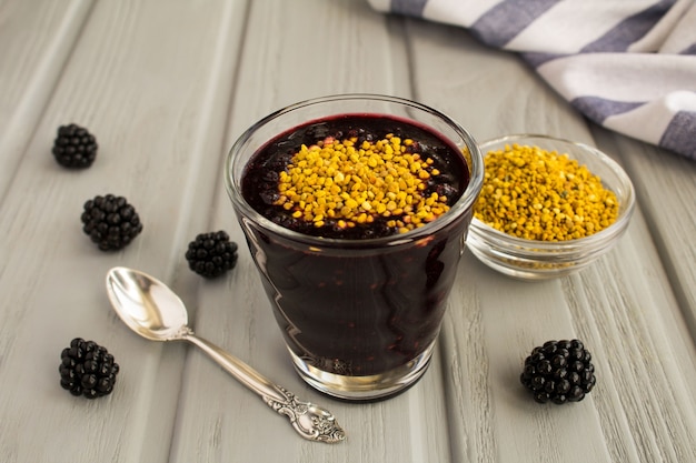 Frullati con mora e polline d'api sul legno grigio