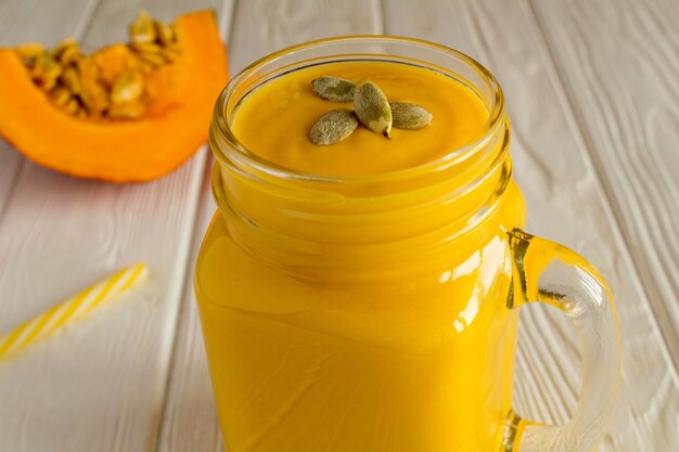 Frullati con zucca su fondo di legno bianco. Primo piano.