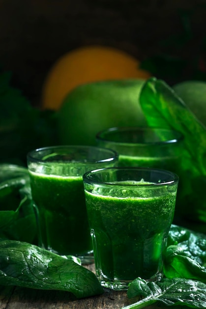 Frullati detox di spinaci verdi con mele e limone in bicchieri messa a fuoco selettiva