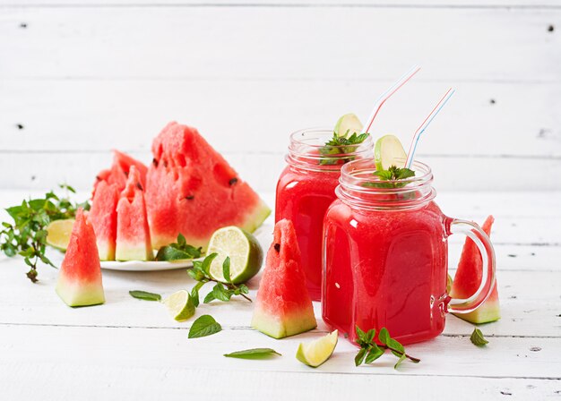 Frullati di anguria fresca con lime e menta sul tavolo di legno bianco