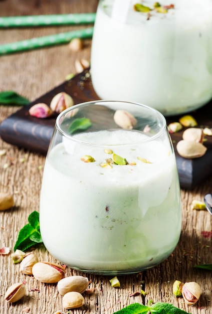 Frullati di milkshake con gelato al pistacchio e menta sfondo legno vintage fuoco selettivo