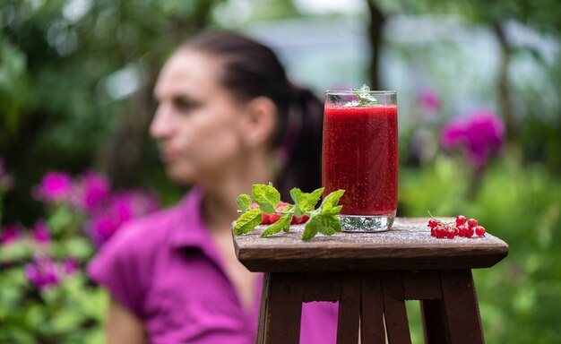 Frullati fruttati di frutti di bosco freschi sullo sfondo di una ragazza