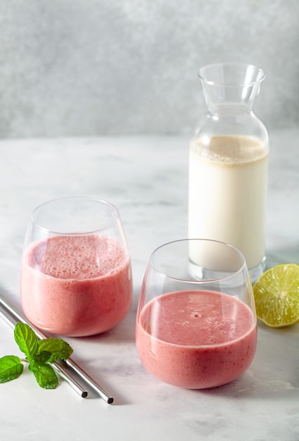 Frullato colazione dolce mattutino a base di latte d'avena, banana e lamponi, con succo di lime