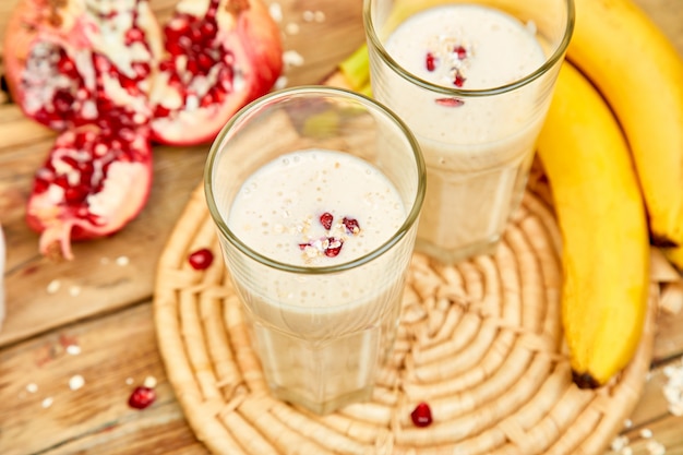 Frullato con avena o farina d'avena, banana e melograno su legno