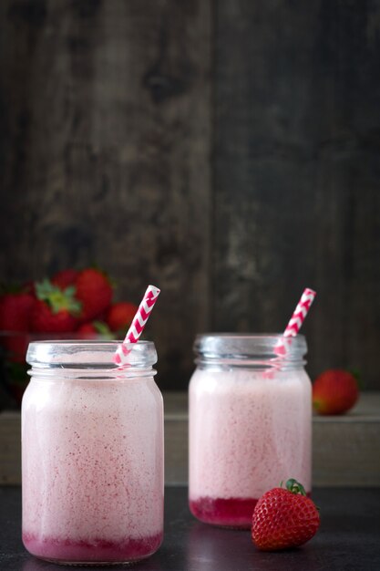 Frullato delizioso della fragola in barattolo sulla tavola di legno