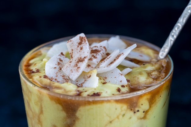 Frullato di avocado verde con caffè nero e scaglie di cocco durante la colazione del mattino