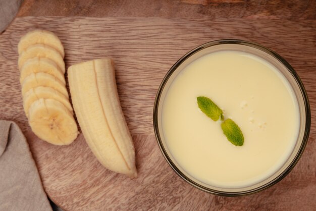 Frullato di banana con menta su tagliere di legno e canovaccio di lino